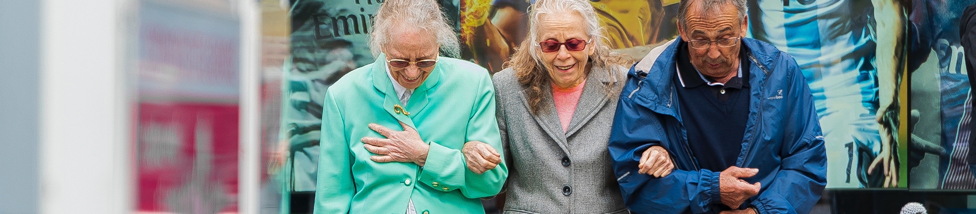 Three elderly friends walking arm in arm Three elderly friends walking arm in arm