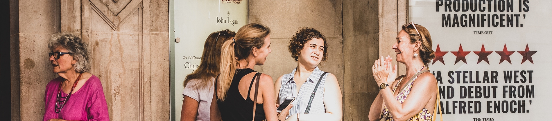A group of women talking outside of a theatre A group of women talking outside of a theatre