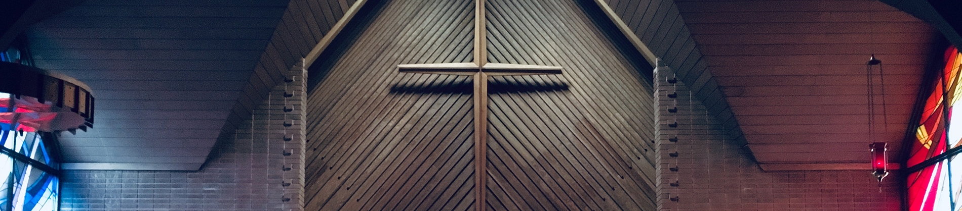 A large wooden cross on a wooden wall of a church A large wooden cross on a wooden wall of a church