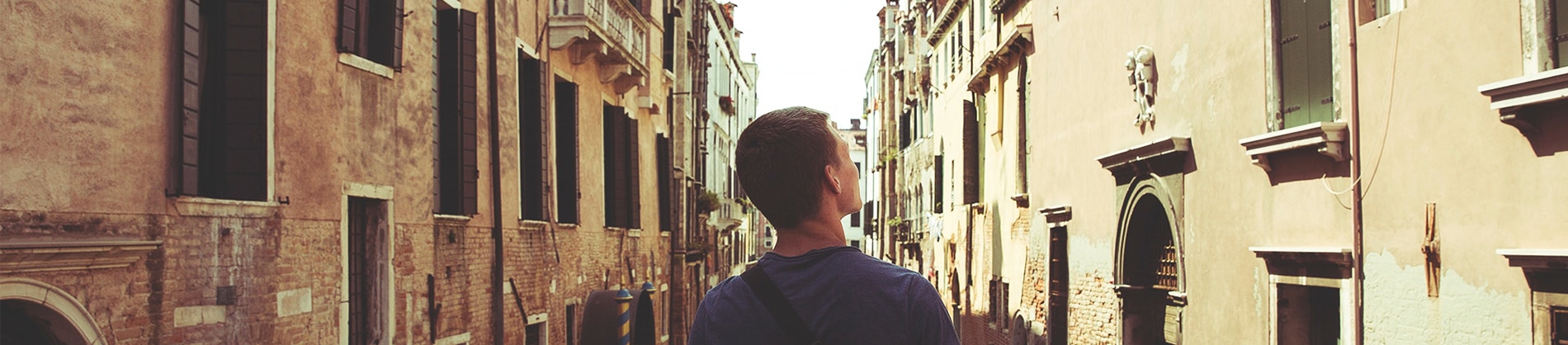 A man stood looking down a row of old buildings A man stood looking down a row of old buildings