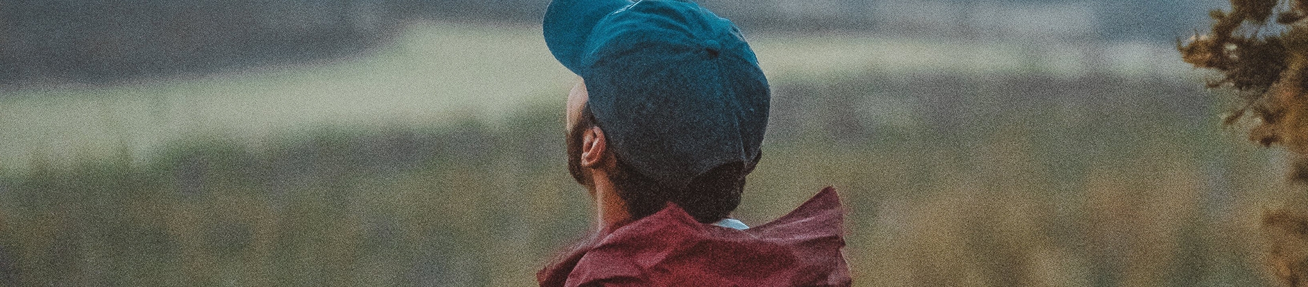 A man in a red coat and blue cap looking up to the sky A man in a red coat and blue cap looking up to the sky