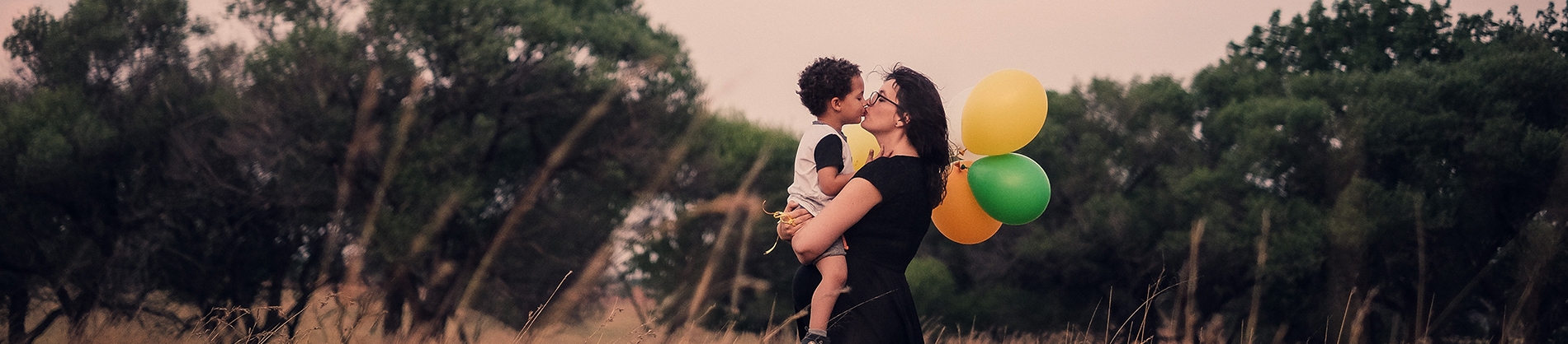 A mother and sun with balloons in a field A mother and sun with balloons in a field