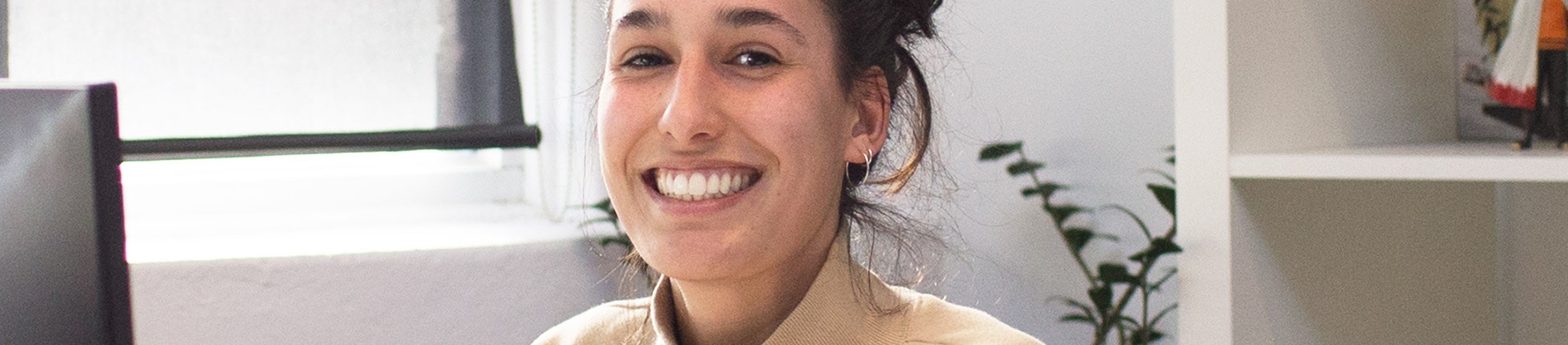 A smiling woman sat at a desk working A smiling woman sat at a desk working