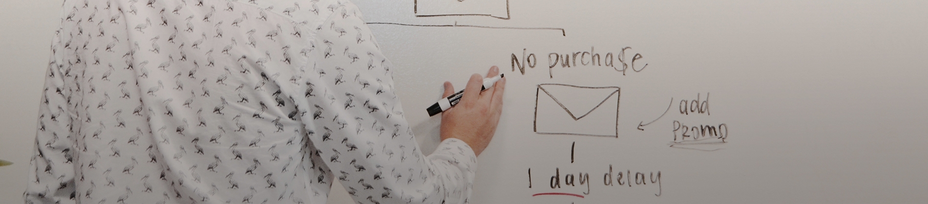 A man writing on a whiteboard A man writing on a whiteboard