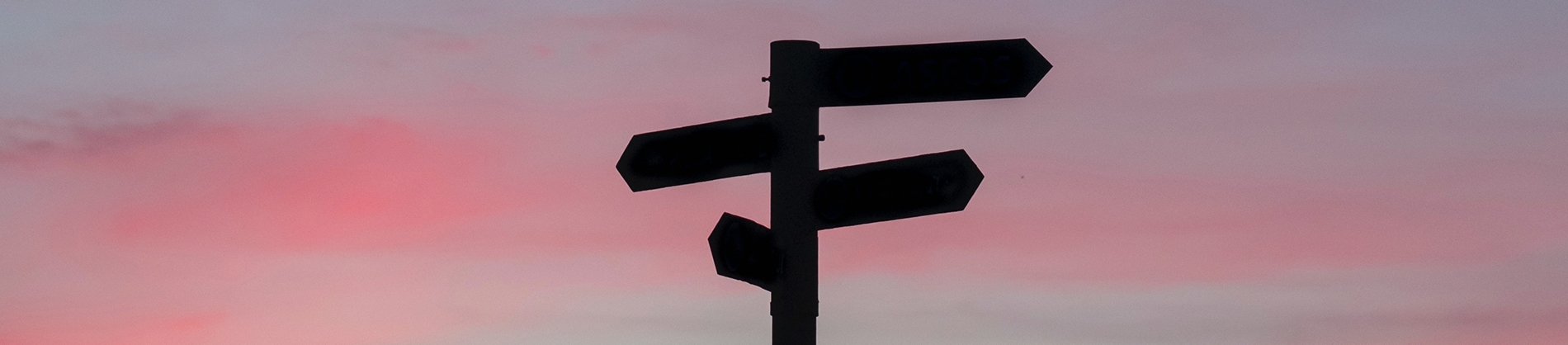 A signpost with a sunset behind A signpost with a sunset behind