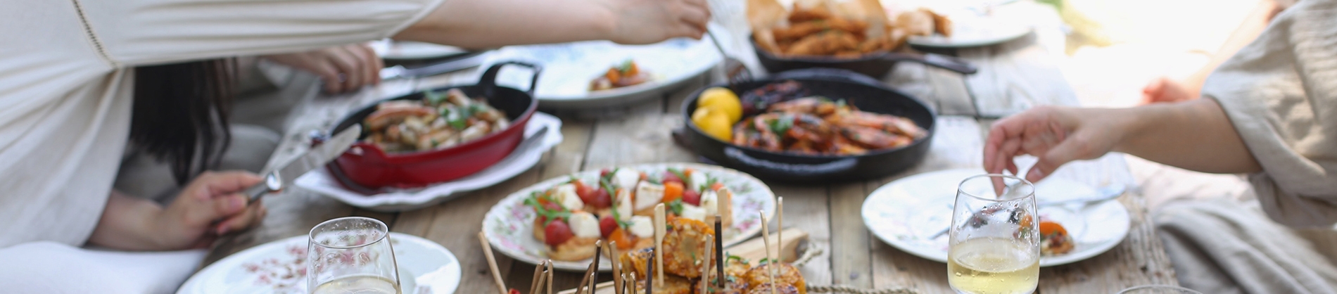 A group of people having a meal on a wooden table A group of people having a meal on a wooden table