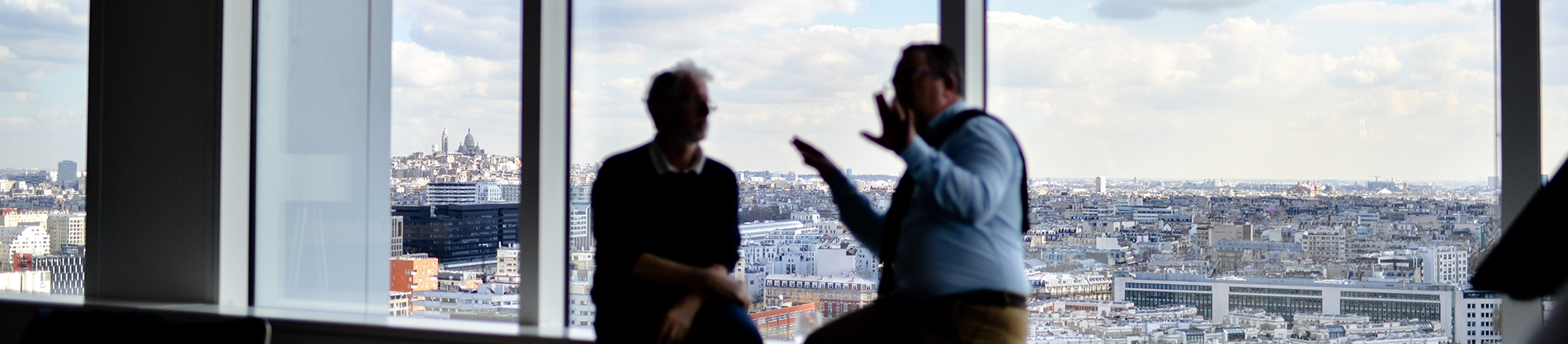 Two men sat on a windowsill talking Two men sat on a windowsill talking