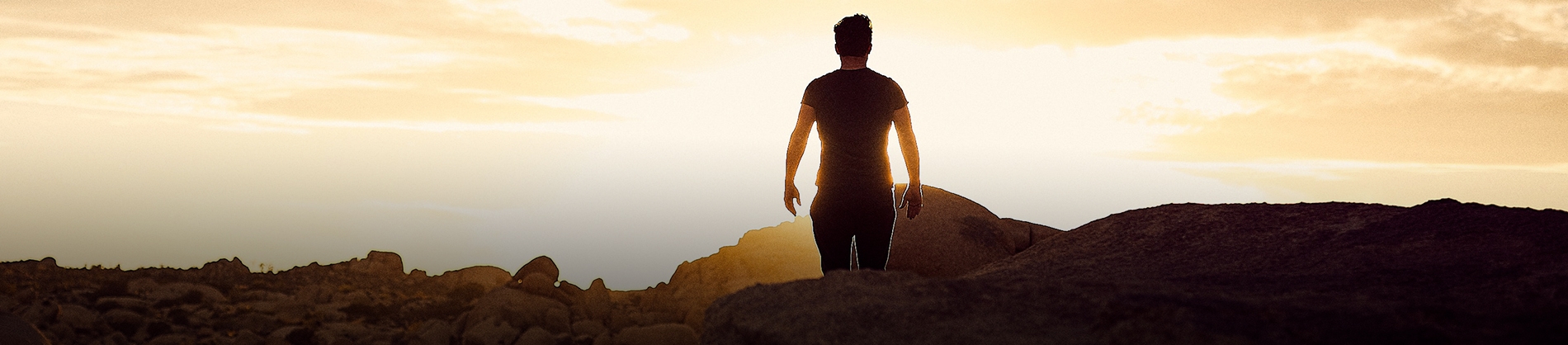 A man walking towards a setting sun A man walking towards a setting sun