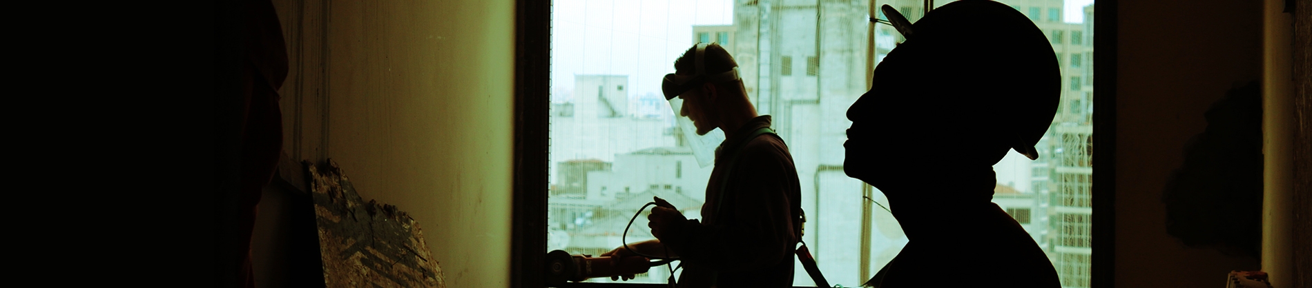 Two men in hard hats working on a building site Two men in hard hats working on a building site