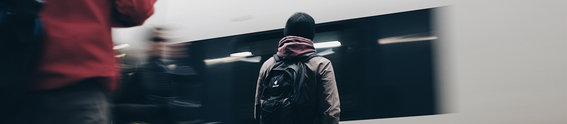 A man on a station platform with a train in front of him A man on a station platform with a train in front of him