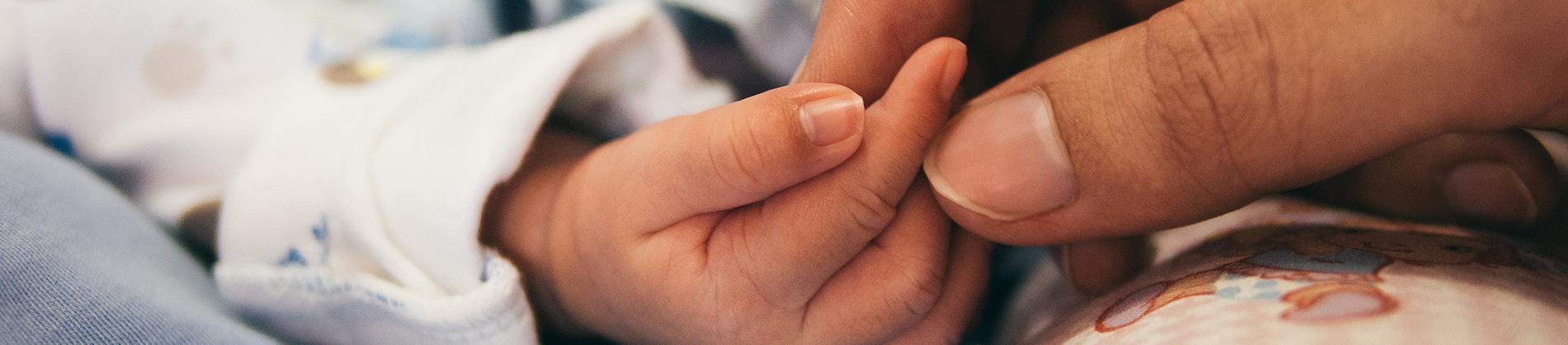 Women holding a babies hand