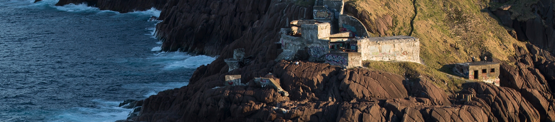 Houses set on a rocky cliff down to the sea