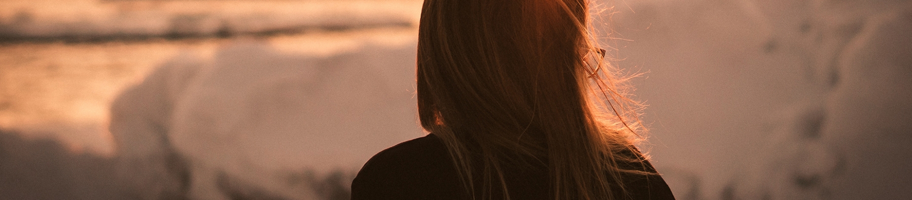 A women looking out over the sea with the sun on her face A women looking out over the sea with the sun on her face