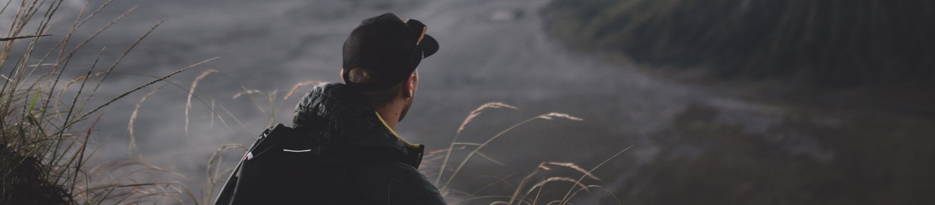 A man sat looking over a valley A man sat looking over a valley