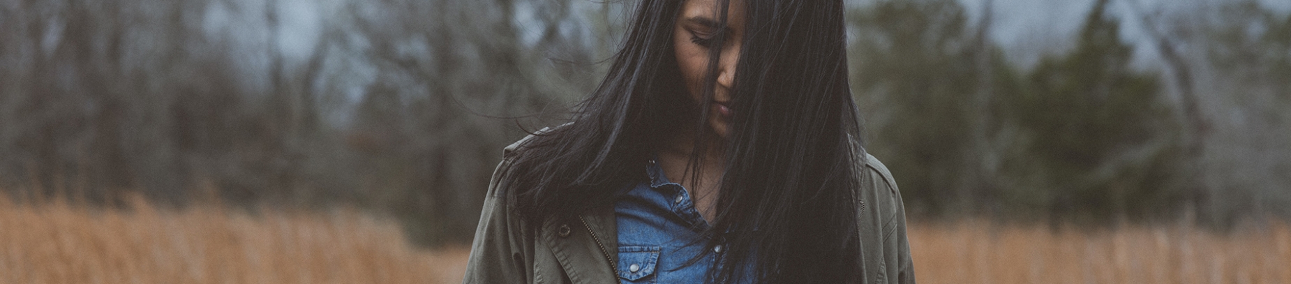 A woman walking through a field, the wind blowing her hair A woman walking through a field, the wind blowing her hair