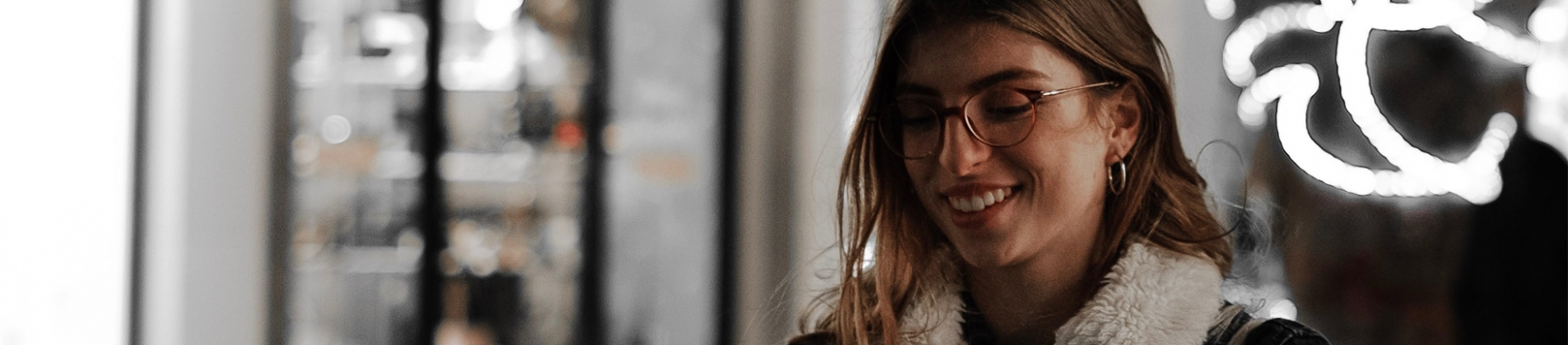 A women smiling and looking down on a lit street A women smiling and looking down on a lit street