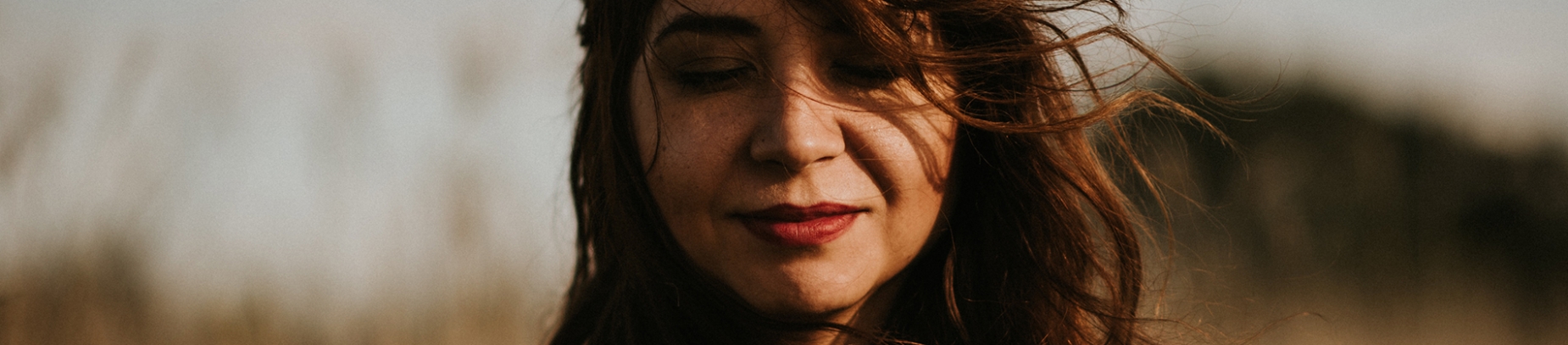 A women with her eyes closed and hair blowing in the wind A women with her eyes closed and hair blowing in the wind