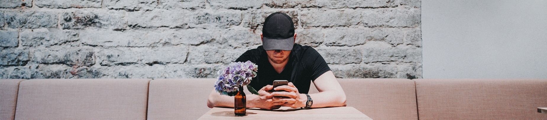 A man sat at a cafe table by himself on his phone A man sat at a cafe table by himself on his phone