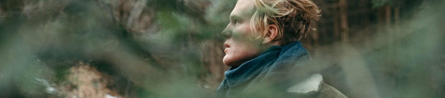 A man in a forest looking anxiously in front A man in a forest looking anxiously in front