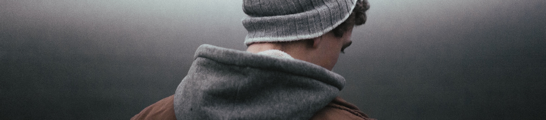 A guy in a beanie hat and hoodie looking down A guy in a beanie hat and hoodie looking down