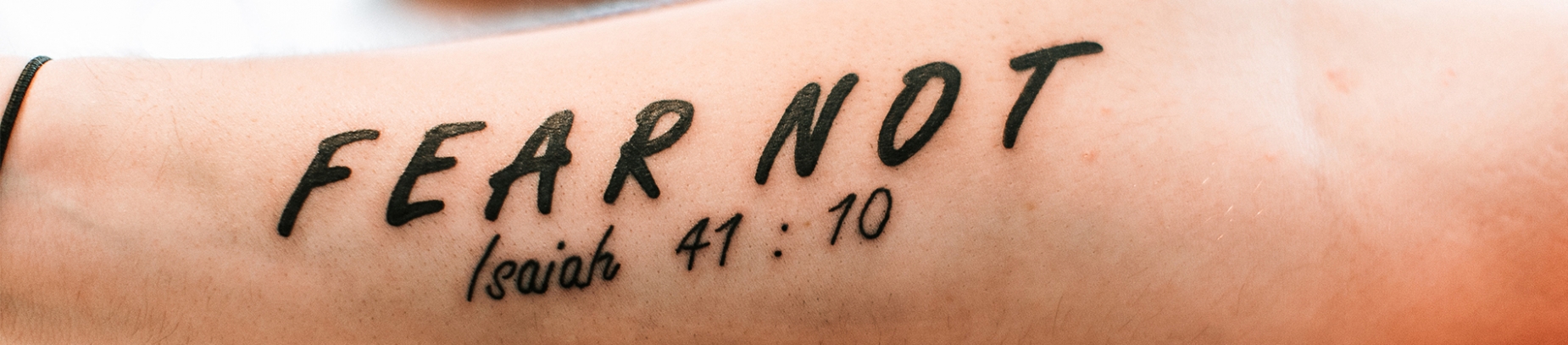 Someones forearm with the words 'Fear not Isaiah 41:10' written on Someones forearm with the words 'Fear not Isaiah 41:10' written on