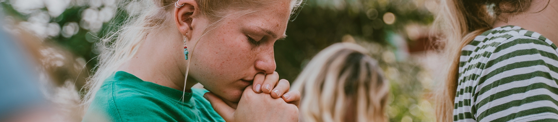 A women with her head bowed and hands together in prayer A women with her head bowed and hands together in prayer