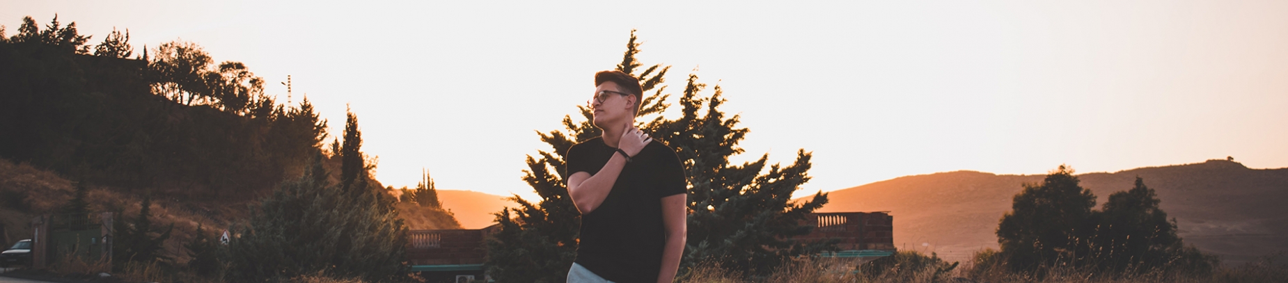 A guy looking up to the sky with the sun rising behind him A guy looking up to the sky with the sun rising behind him