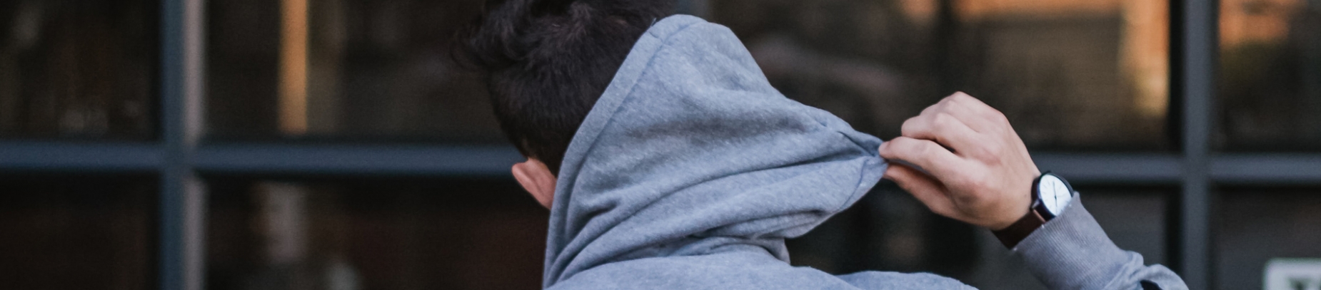 A guy pulling down his hoodie hood off his head A guy pulling down his hoodie hood off his head