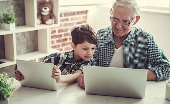 Grandad and Grandson on laptops Grandad and Grandson on laptops